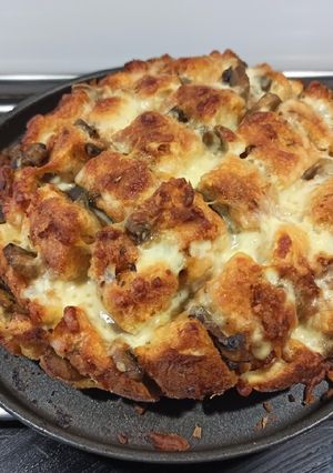 Una foto de Hogaza de ajo, queso, tomate y champiñones