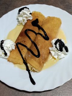 Una foto de Filloas rellenas de crema con nata y chocolate