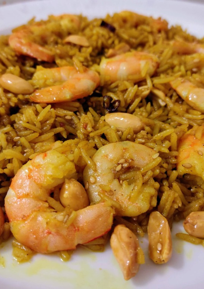 Una foto de Arroz jazmín frito con curry, cacahuetes, sésamo, miel y langostinos