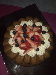Una foto de Brownie con dulce de leche, Chantilly, frutillas y arándanos