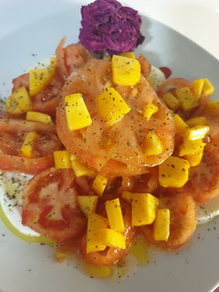 Una foto de Ensalada de tomate raf, pera, melocotón y mozzarella