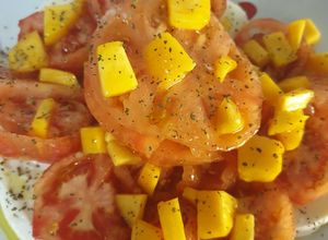Una foto de Ensalada de tomate raf, pera, melocotón y mozzarella