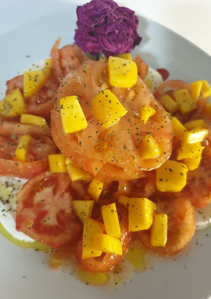 Una foto de Ensalada de tomate raf, pera, melocotón y mozzarella