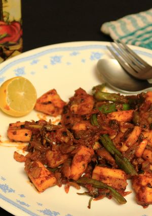 A picture of Squid cubes and beans stir fry in kerala spicy-roast coating.