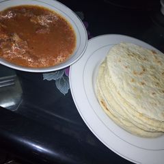 A picture of Pita bread with meat soup.