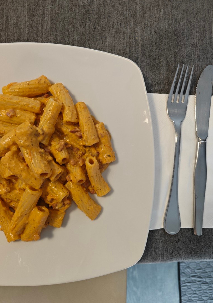 Una foto de Rigatoni con salsa de tomates cherry y queso feta con jamón serrano