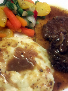 A picture of Hamburger Steak w/ Onions & Gravy.
