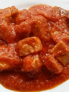 Una foto de Carne y asadura de cerdo con tomate