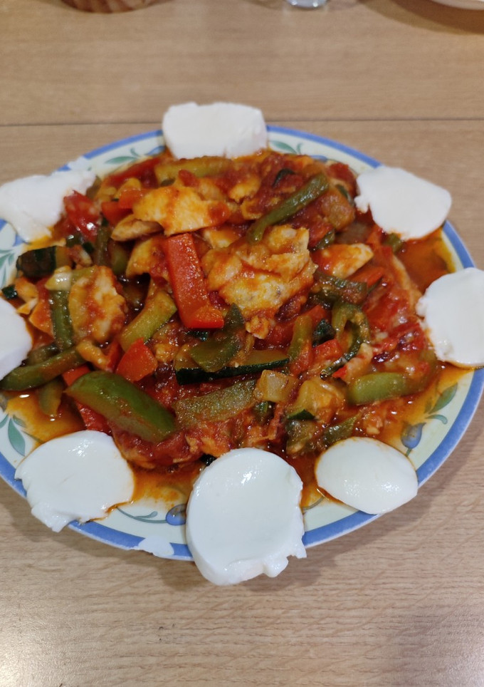 Una foto de Merluza en salsa de tomate y verduras con queso