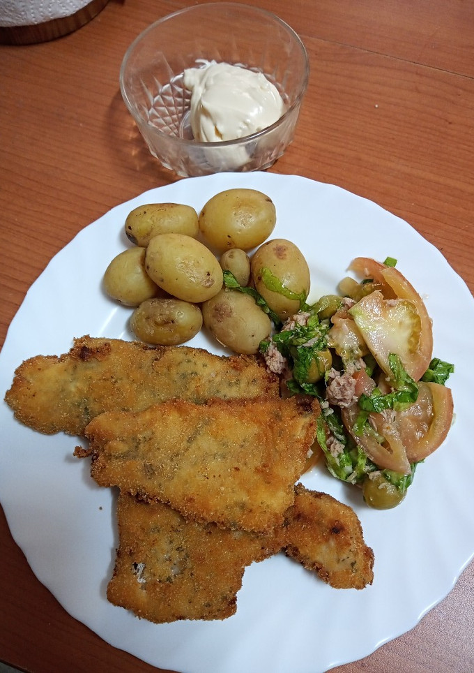 Una foto de Merluza aromatizada de cítricos con ensalada y papas cocidas