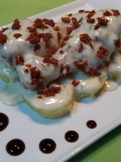 Una foto de Muslos de pollo con bechamel al orégano y tomates secos