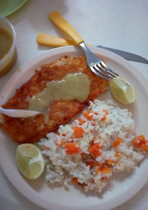 Una foto de Pescado empanizado con arroz con zanahoria