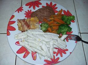 Una foto de Pechuga de pollo rellena con guarnición de verduras y pasta