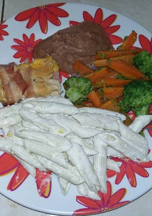 Una foto de Pechuga de pollo rellena con guarnición de verduras y pasta