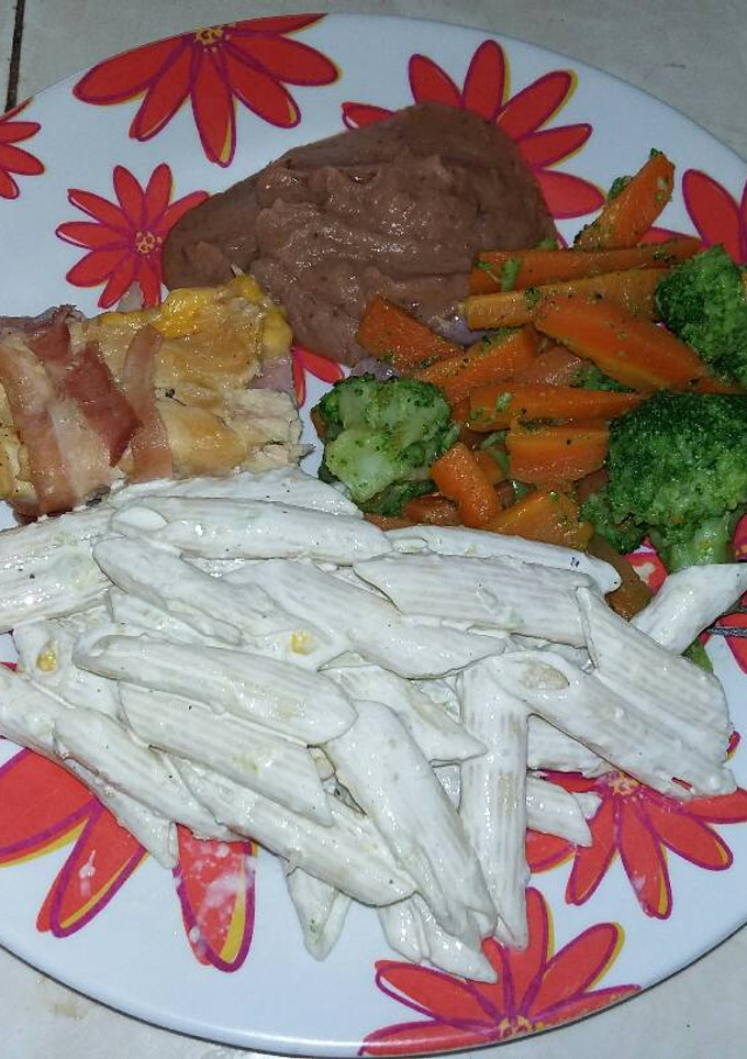 Una foto de Pechuga de pollo rellena con guarnición de verduras y pasta