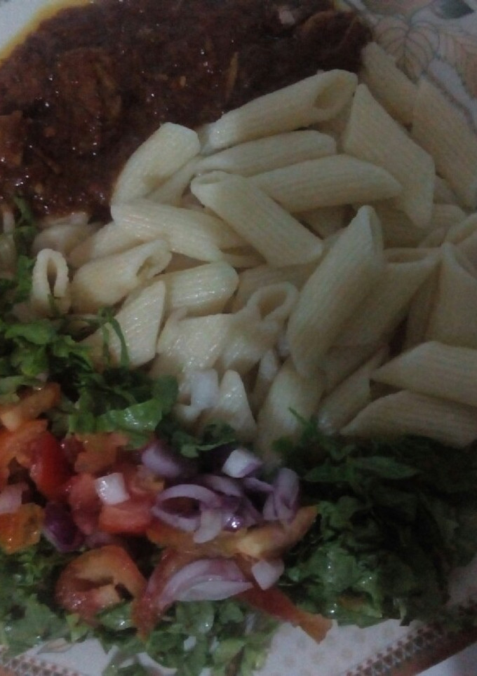 A picture of Macroni and stew with salad.