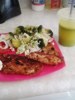 Una foto de Pechuga rellena con verduras al vapor, acompañada de jugo verde