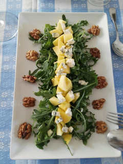 Una foto de Ensalada de rúcula, mango, queso azul y nueces
