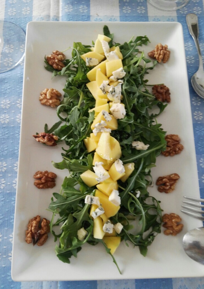 Una foto de Ensalada de rúcula, mango, queso azul y nueces