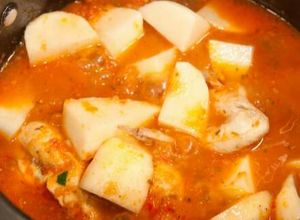 Una foto de Pollo entomatado con papas