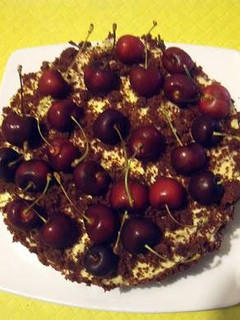 A picture of Red Velvet Cake with Orange Cream Cheese Icing and Cherries.