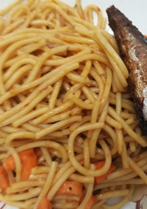A picture of Spagetti with carrots and fried fish.