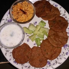 A picture of Singhare ke aate ki poori with crumbled paneer and chaas.
