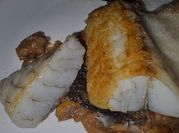 Una foto de corvina en salsa de marisco