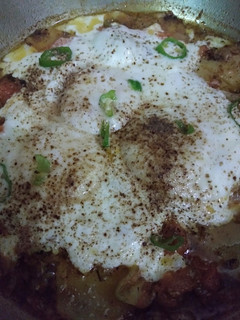A picture of Poached Eggs with spicy Tomatoes and Potato.