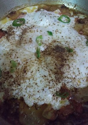 A picture of Poached Eggs with spicy Tomatoes and Potato.