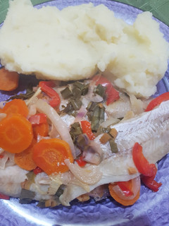 Una foto de Merluza al horno con vegetales, ensalada y puré