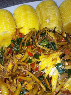 A picture of Ripe plantain with ugba sauce.