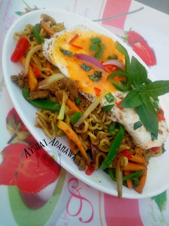 A picture of Aisha's Special stir fry noodles with minced meat and sunny side up egg.