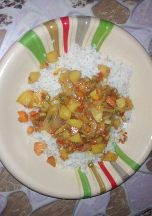 A picture of White rice with vegetable soup.