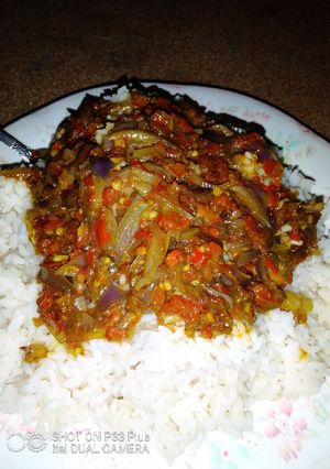 A picture of White rice with pepper sauce.