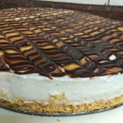 A picture of Vanilla cheesecake topped with chocolate and caramel.