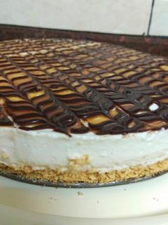A picture of Vanilla cheesecake topped with chocolate and caramel.