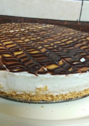 A picture of Vanilla cheesecake topped with chocolate and caramel.