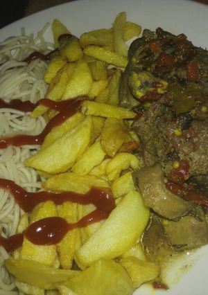 A picture of Pasta with fries and peppered meat sauce.