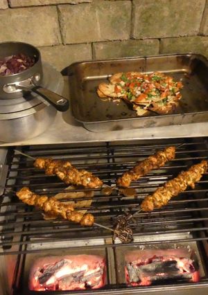 A picture of Chicken satay kebabs and home made pili pili cheesy chapati nachos in the jiko oven :).