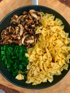 Una foto de Farfalle con champiñones, espinacas y parmesano