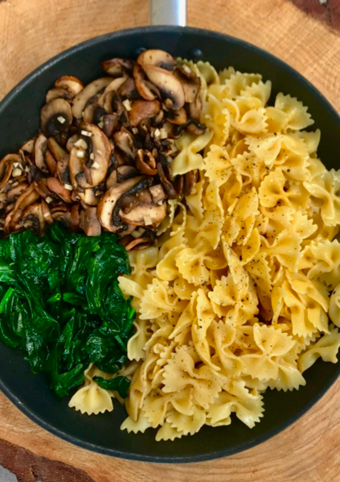 Una foto de Farfalle con champiñones, espinacas y parmesano