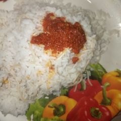 A picture of Ofada rice with pasta and palm oil stew.