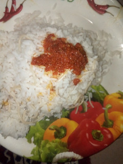 A picture of Ofada rice with pasta and palm oil stew.