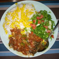 A picture of White rice,curried maca with fish stew and salad.