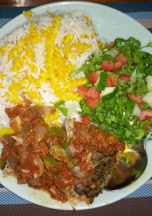 A picture of White rice,curried maca with fish stew and salad.
