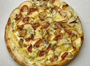 Una foto de Pizza con mozarela, queso azul, peras, panceta, nueces y un hilo de miel - masa prefermento poolish