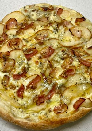 Una foto de Pizza con mozarela, queso azul, peras, panceta, nueces y un hilo de miel - masa prefermento poolish