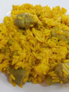 Una foto de Arroz con pollo, guisantes y alcachofas