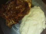 Una foto de pure y chuletas